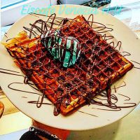 Frische selbstgemachte Waffel mit Pistazieneis und Schokoladensause Frische selbstgemachte Waffel mit Pistazieneis und Schokoladensause