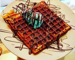 Frische selbstgemachte Waffel mit Pistazieneis und Schokoladensause