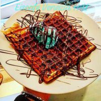 Frische selbstgemachte Waffel mit Pistazieneis und Schokoladensause Frische selbstgemachte Waffel mit Pistazieneis und Schokoladensause